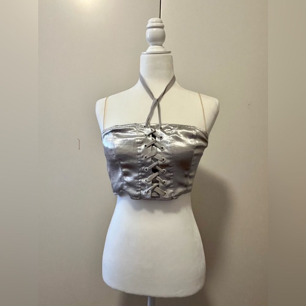 Silver shimmer crop top with shoe lace going up customize around next. Cute top!